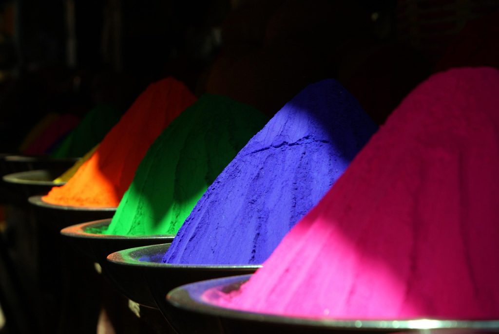 Colorful piles of Holi gulal powder in vibrant shades arranged in bowls for festival celebrations